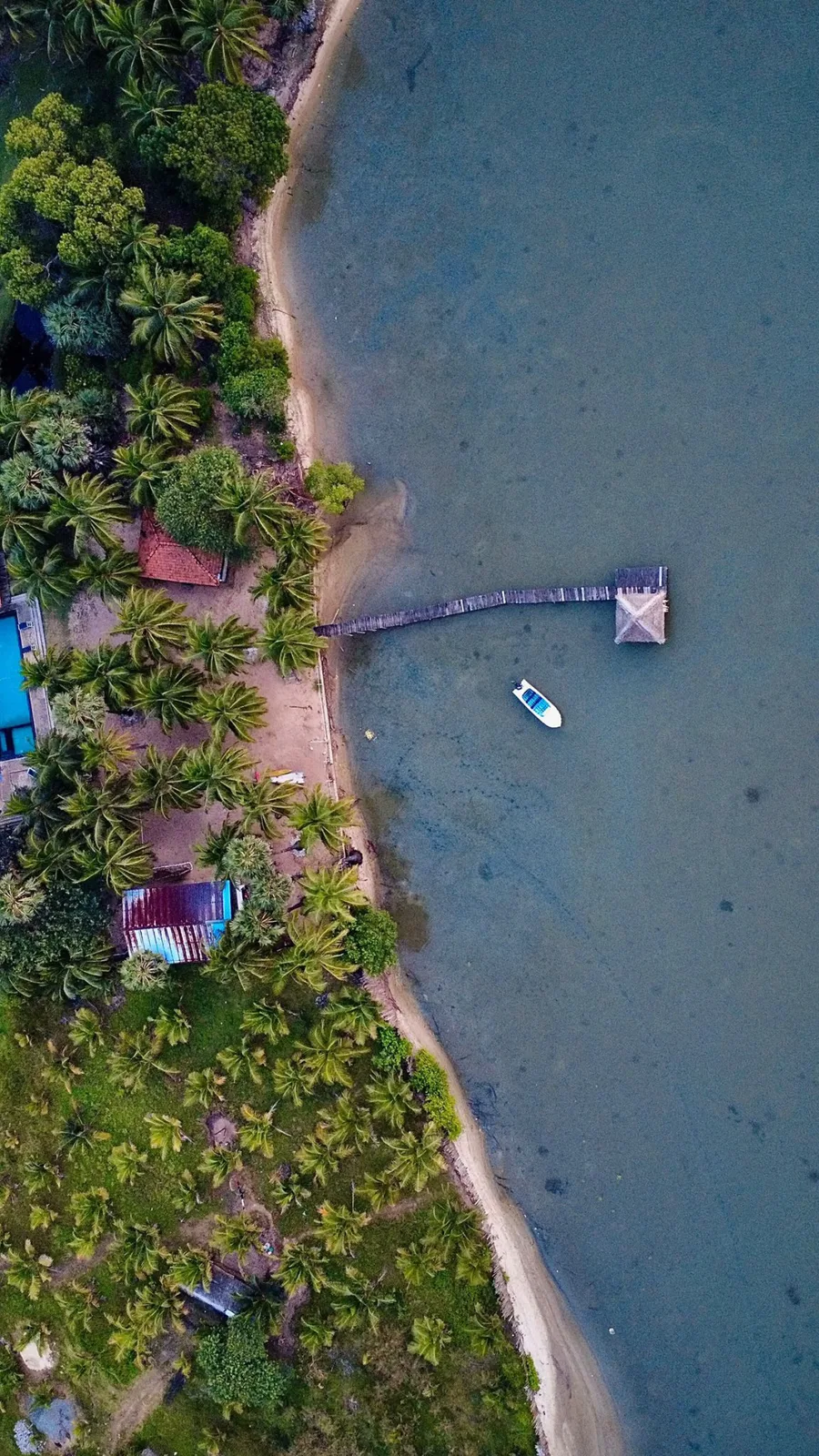 Aerial view of Valampuri Resort on the Kalpitiya lagoon shore — pool, jetty and boat
